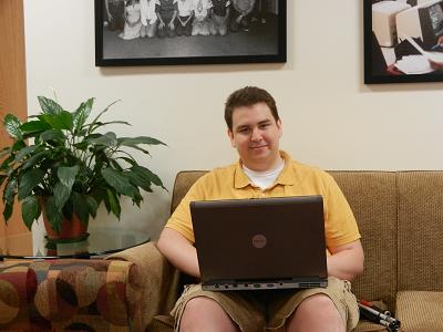 Picture of Sean Mealin sitting on the couch with his laptop